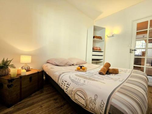 une chambre avec un lit et une table avec une lampe dans l'établissement Le Pastel - centre ville - clim, à Nîmes