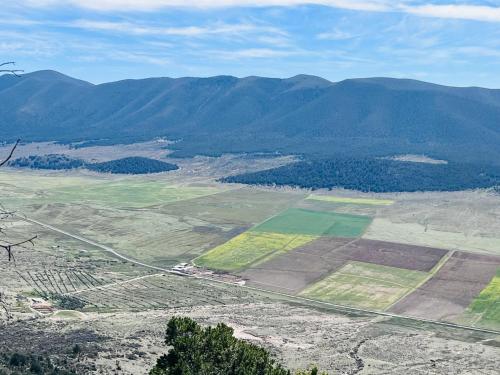 an aerial view of a field with mountains in the background at Casa De Campo Mirador H&L in San Antonio de las Alzanas