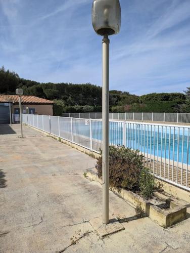 un pôle lumineux à côté d'une piscine dans l'établissement T2 à 200m de la mer et commerces, à Six-Fours-les-Plages