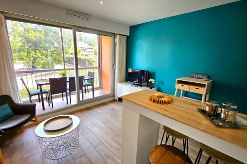 une cuisine avec un mur bleu, une table et des chaises dans l'établissement Renovated apartment with balcony and modern style, à Saint-Mandrier-sur-Mer