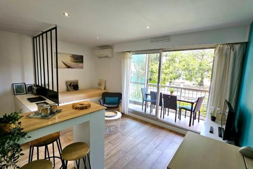 une pièce avec une cuisine et un salon avec un balcon dans l'établissement Renovated apartment with balcony and modern style, à Saint-Mandrier-sur-Mer