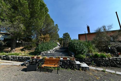 a wooden bench sitting next to a set of stairs at Etna Volcano Relais- Indipendent Villa in Mascalucia