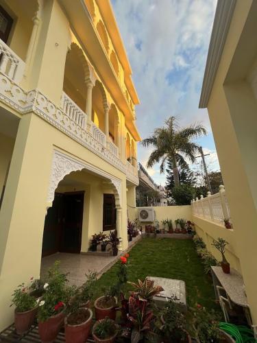a house with a yard with potted plants at Chitawa Haveli jaipur in Jaipur