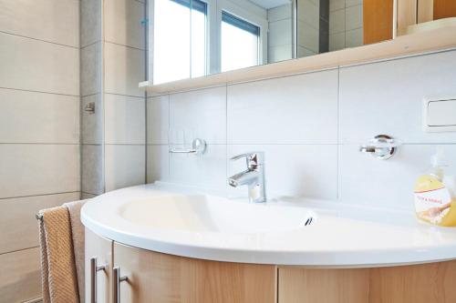 łazienka z białą umywalką i lustrem w obiekcie Apartments Kirchebnerhof w mieście Oetz