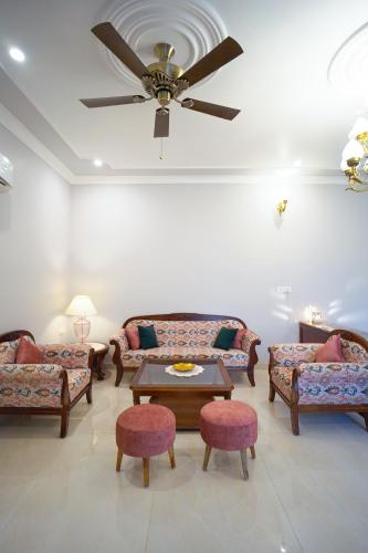 a living room with couches and a ceiling fan at Chitawa Haveli jaipur in Jaipur