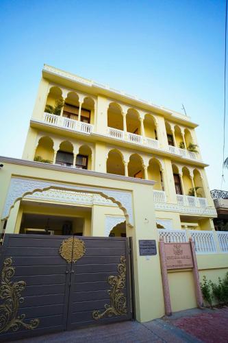 a large yellow building with a gate in front of it at Chitawa Haveli jaipur in Jaipur