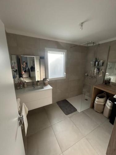 une salle de bain avec une douche et un lavabo et une fenêtre dans l'établissement T3 neuf Porticcio centre, à Porticcio