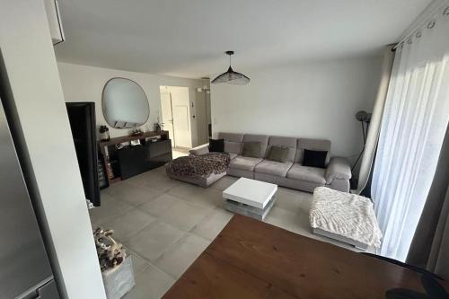 un salon avec un canapé et un miroir dans l'établissement T3 neuf Porticcio centre, à Porticcio