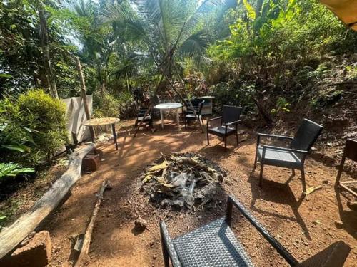 un grupo de sillas y mesas en un patio en The Caveman Goa-River-view Retreat., en Arambol