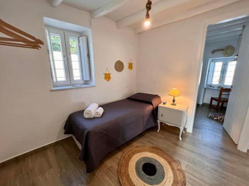 a bedroom with a bed and a table and a window at Dall'Egeo παραδοσιακό κυκλαδίτικο σπίτι in Vari