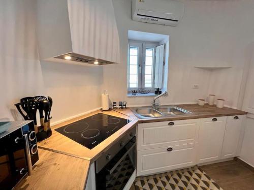 a kitchen with a stove and a sink in it at Dall'Egeo παραδοσιακό κυκλαδίτικο σπίτι in Vari