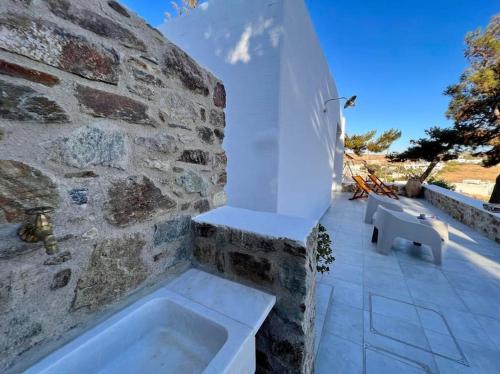 a bathroom with a bath tub in a stone wall at Dall'Egeo παραδοσιακό κυκλαδίτικο σπίτι in Vari
