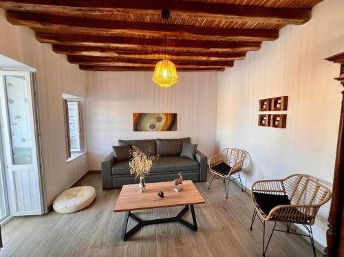a living room with a couch and a table at Dall'Egeo παραδοσιακό κυκλαδίτικο σπίτι in Vari