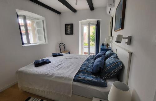 a bedroom with a large bed with blue pillows at Old town STONE HOUSE OASIS in Selce