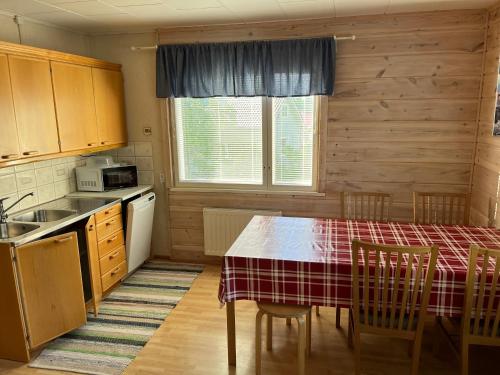 eine Küche mit einem Tisch, einem Tisch und Stühlen in der Unterkunft SportHome in Rovaniemi