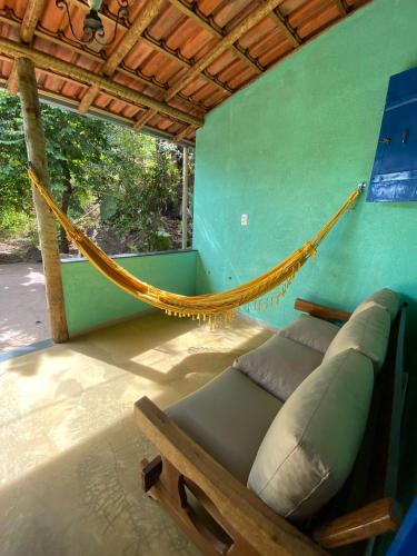 a hammock in a room with a green wall at Embaúbas suíte privativa in Serra do Cipo