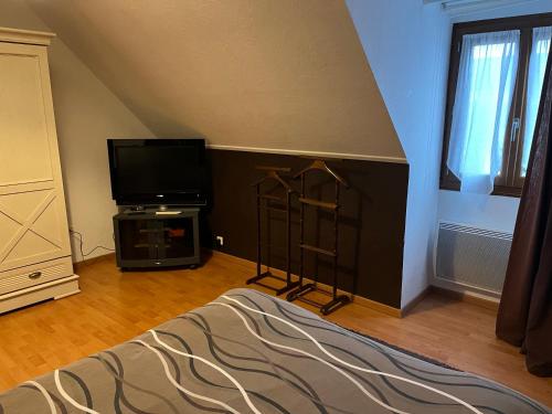 un salon avec une télévision et un lit dans l'établissement Corbel, à Châtenay-Malabry