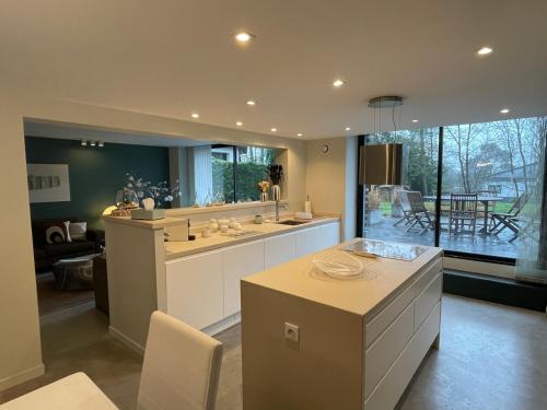 une grande cuisine avec une table et une grande fenêtre dans l'établissement LA GLANERIE, à Le Touquet-Paris-Plage