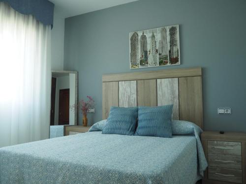 a bedroom with a bed with blue sheets and a mirror at O Cunchal Rooms in Dena