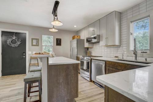 a kitchen with stainless steel appliances and wooden cabinets at Red Rock Loft! Trails Apartment w BBQ & Fire Pit in Colorado Springs