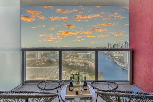 a room with a table and chairs and a large window at Modern Resort Apartment with Balcony Pool Gym in Hallandale Beach