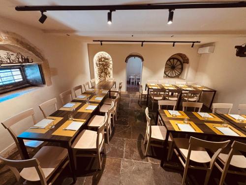 a dining room with long tables and white chairs at Locanda Angelica in Giarratana
