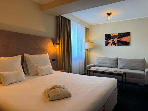 pokój hotelowy z łóżkiem i kanapą w obiekcie Amber Blue Wellness & SPA w Karwii