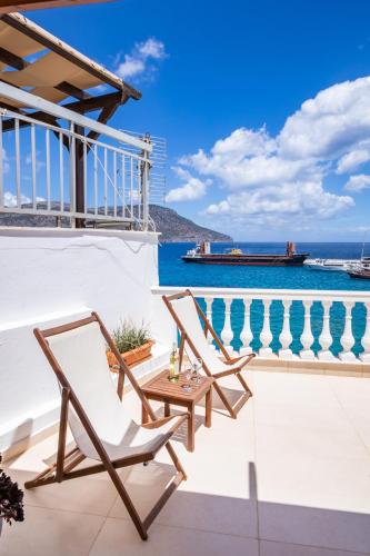a balcony with two chairs and a table and the ocean at Mimis & Connie 2 in Karpathos Town
