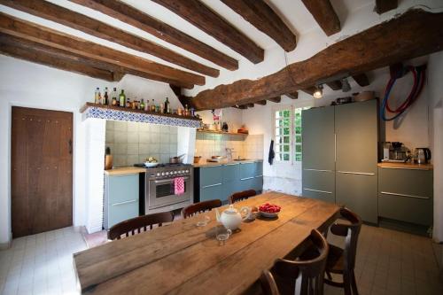 une grande cuisine avec une table et des chaises en bois dans l'établissement Huis op een eiland in de Loire, à Gennes