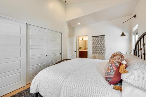 a white bedroom with a large bed with white doors at Views and Hot Tub Pineberry Modern Luxury Home in Pine
