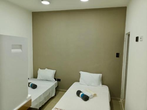 2 łóżka w pokoju z białymi ścianami w obiekcie Casa Mango w mieście Cali