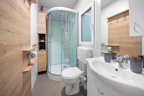a bathroom with a toilet and a glass shower at Glamping Lucky House in Gradac
