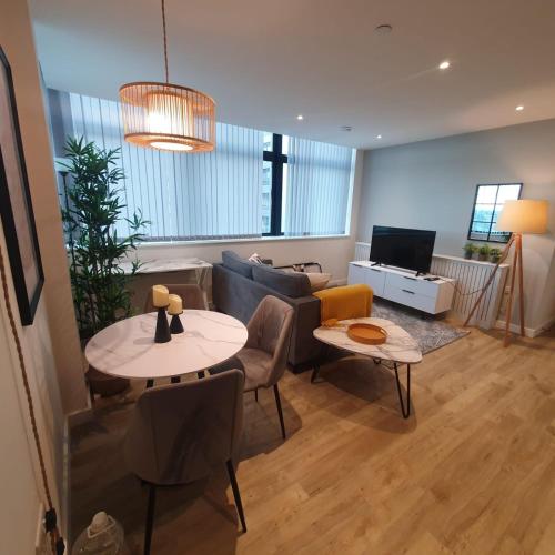 a living room with a couch and a table at Lovely 1 Bed Apartment - Old Trafford in Manchester