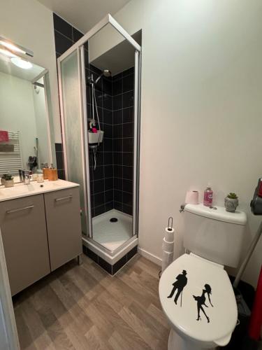 une salle de bain avec des toilettes avec deux personnes dessus dans l'établissement Studio urbain à 2 pas de Paris, à Nanterre