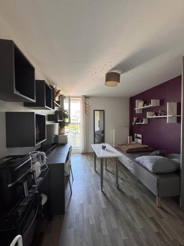 une pièce avec un lit et une table dedans dans l'établissement Studio urbain à 2 pas de Paris, à Nanterre