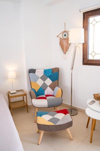 a living room with a chair and a lamp at Mimis & Connie 2 in Karpathos Town