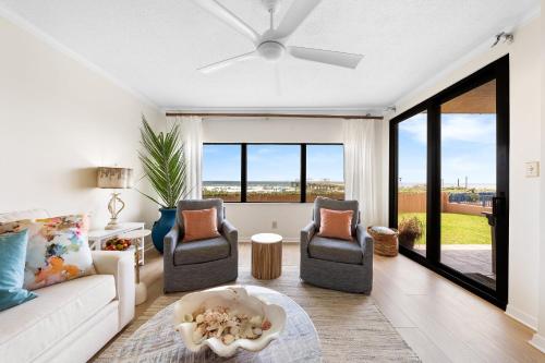 a living room with a couch and two chairs at Four Seasons 103E by Vacation Homes Collection in Orange Beach