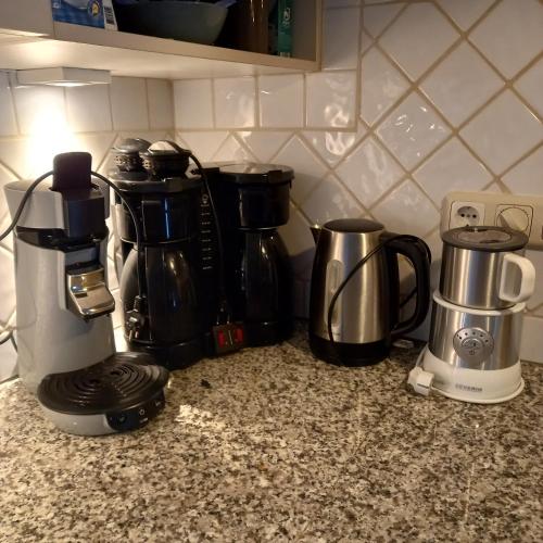 a group of coffee makers on a kitchen counter at Vakantiehuis met sauna en jacuzzie in Lunteren