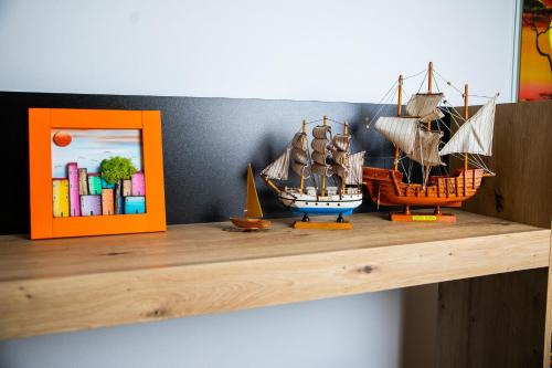 twee modelschepen op een plank met een boek bij Lena`s Home in Subotica