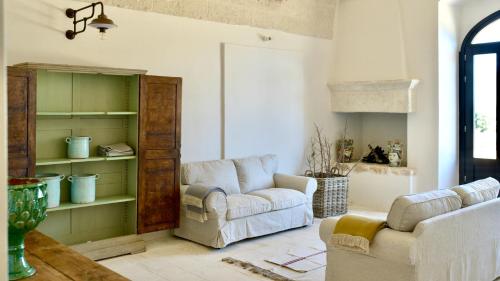 sala de estar con 2 sillas y sofá en Masseria Celeste, en Fasano