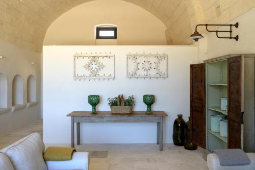 una sala de estar con una mesa con jarrones. en Masseria Celeste, en Fasano