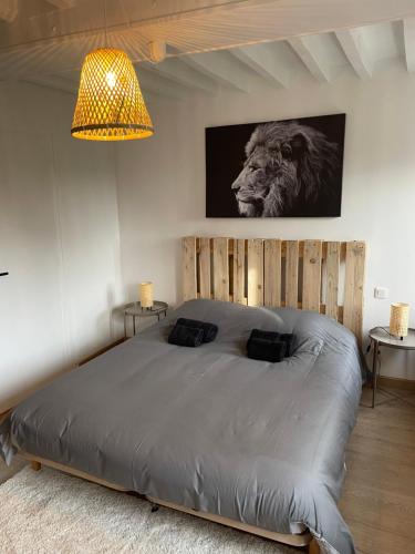 - une chambre dotée d'un lit avec un lion sur le mur dans l'établissement La maison de l'olivier, à Poses