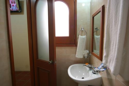 y baño con lavabo y espejo. en Hotel Oaxaca Mágico, en Oaxaca City