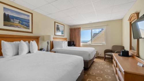 a hotel room with two beds and a television at Safari Hotel Boardwalk in Ocean City