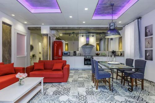 Una sala de estar con un sofá rojo y una mesa. en Fouxia-Grey, en Skopelos Town