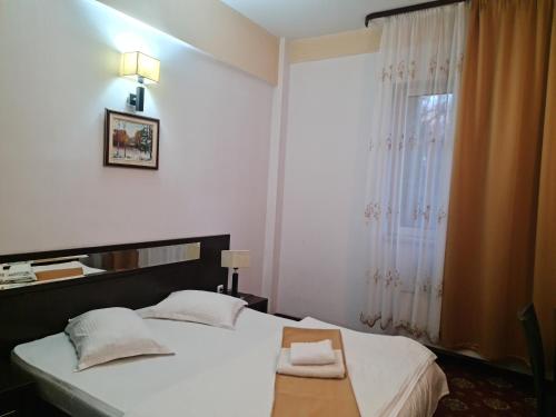 a bedroom with a bed and a window at Hotel Magic GT Trivale in Piteşti