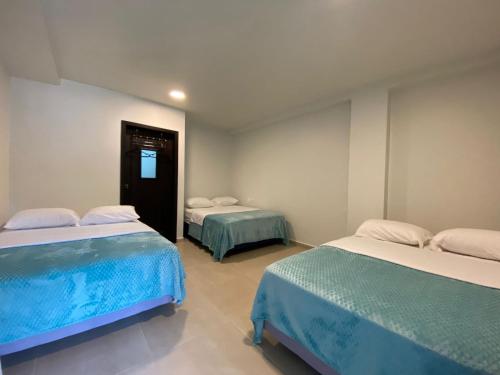 a room with two beds and a hallway with two at Presidencial Penthouse - 2 Bedrooms 3 Bath in Baños