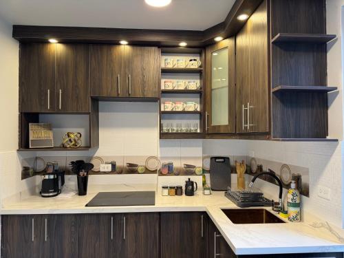 a kitchen with wooden cabinets and a counter top at Presidencial Penthouse - 2 Bedrooms 3 Bath in Baños
