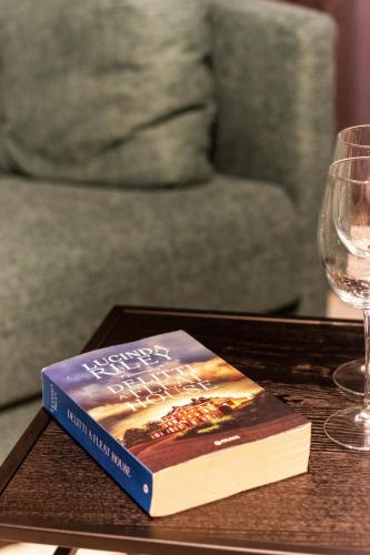 a book sitting on a table next to a wine glass at Residenza San Longino in Mantova