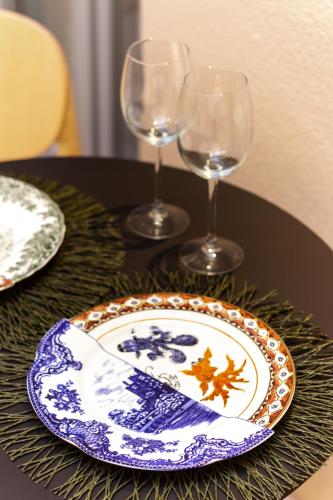 a table with a plate and two wine glasses at Residenza San Longino in Mantova